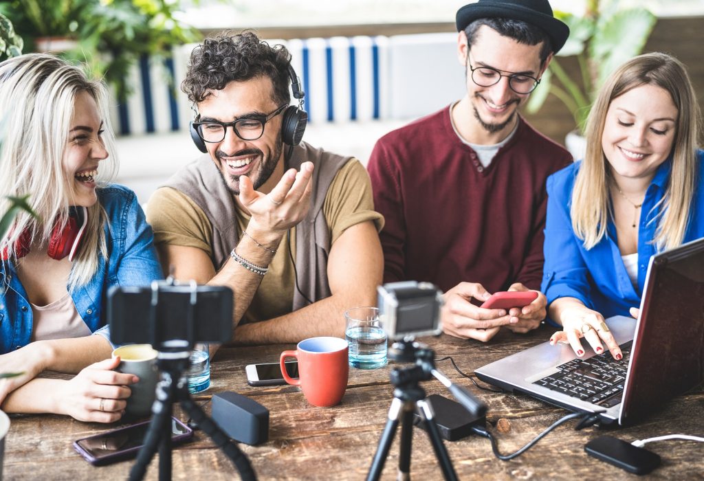 Young happy friends sharing content on streaming platform with digital web camera - Modern marketing concept with millenial guys and girls having fun vlogging live feeds on social media network